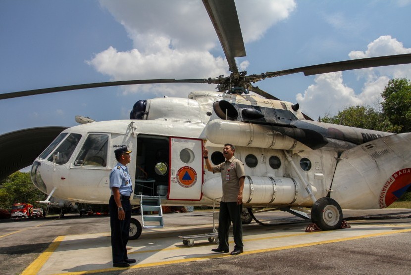 Kepala Badan Penanggulangan Bencana Daerah (BPBD) Provinsi Riau Edward Sanger (kanan) didampingi Kadisops Lanud Roesmin Nurjadin Kol Pnb Jajang Setiawan (kiri) meninjau kesiapan Helikopter Water Bombing di Pekanbaru, Riau, Senin (29/7/2019). 