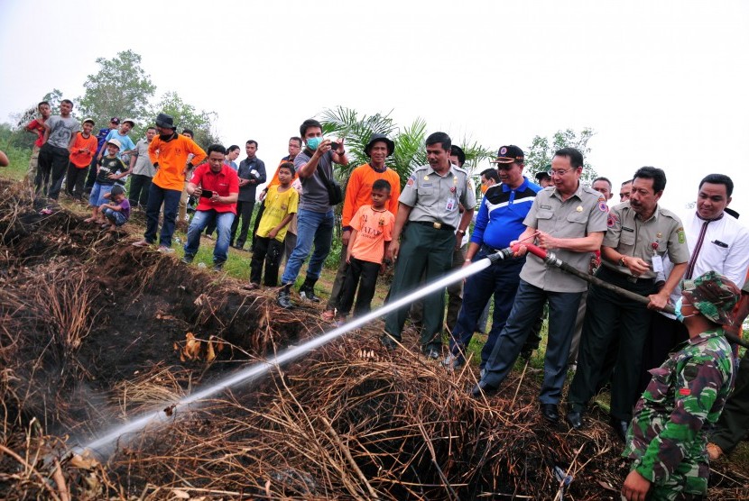 Kepala Badan Penanggulangan Bencana Nasional (BNPB) Willem Rampangilei mencoba memadamkan api yang ketika terjadi kebakaran di lahan gambut Rimbo Panjang Kabupaten Kampar, Riau, Rabu (9/9). 