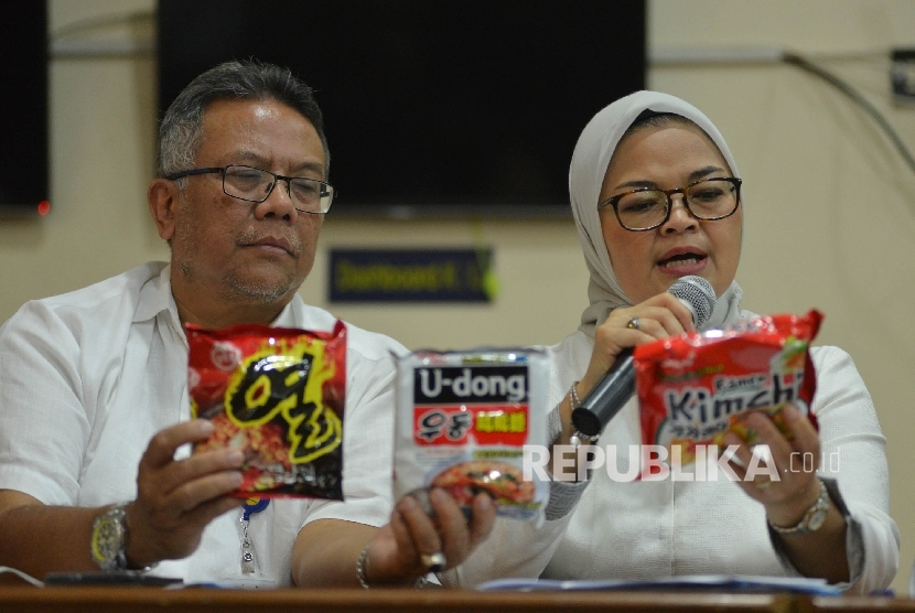 Kepala Badan Pengawan Obat dan Makanan (BPOM) Penny Kusumastuti Lukito (kanan) bersama Deputi Bidang Pengawasan Keamanan Pangan dan Bahan Berbahaya Suratmono (kiri) menunjukan mie yang mengandung minyak babi saat menggelar konferensi pers di Pelabuhan Tanjung Priok, Jakarta Utara, Senin (19/6).