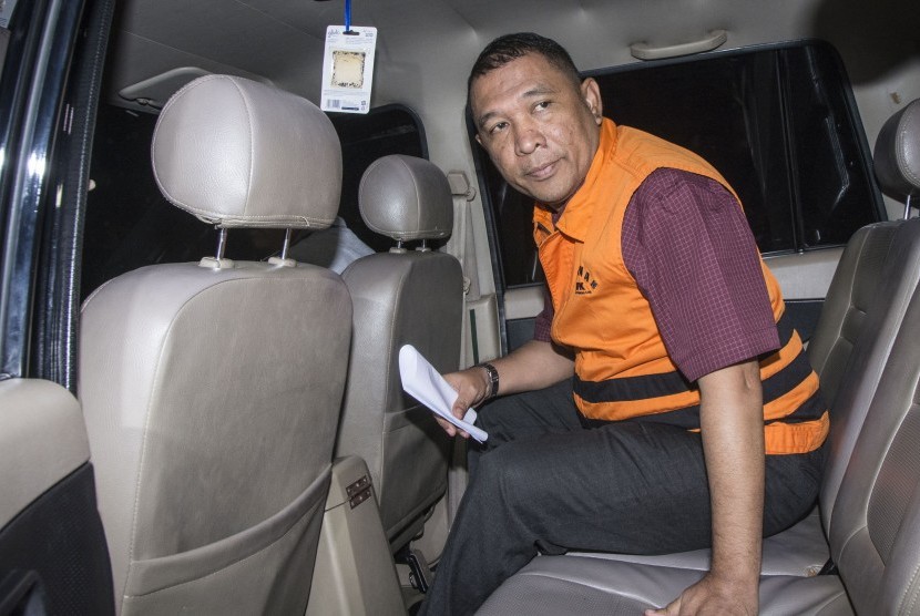 Kepala Badan Perizinan Terpadu dan Penanaman Modal Kota Cilegon Ahmad Dita Prawira menggunakan rompi tahanan masuk ke mobil tahanan seusai menjalani pemeriksaan di Gedung KPK, Jakarta, Minggu (24/9). 