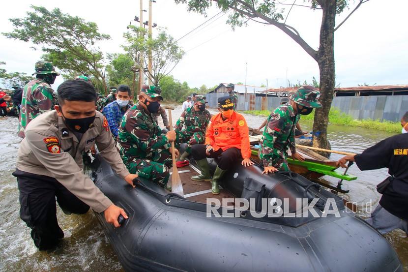 Kepala Badan SAR Nasional (Basarnas) Marsekal Madya TNI Purn Bagus Puruhito (kedua kanan) menggunakan perahu karet meninjau banjir di kawasan Desa Pembataan, Banjarbaru, Kalimantan Selatan, Sabtu (16/1/2021). 
