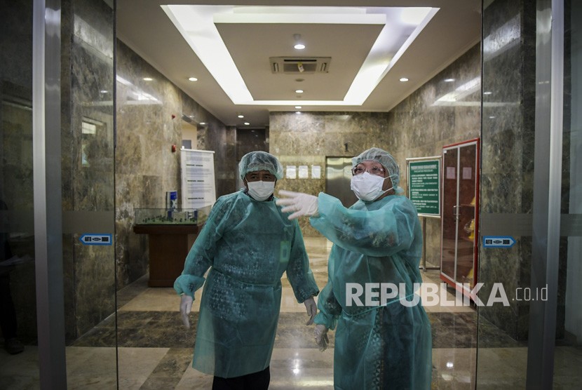 Kepala Balitbangkes Kementerian Kesehatan Siswanto (kiri) bersama Kepala Pusat Penelitian dan Pengembangan Biomedis dan Teknologi Dasar Kesehatan Kementerian Kesehatan Vivi Setiawaty (kanan) mengenakan pakaian steril saat akan memasuki Labotarium Badan Penelitian dan Pengembangan Kesehatan (Balitbangkes) di Jakarta, Selasa (11/2/2020).