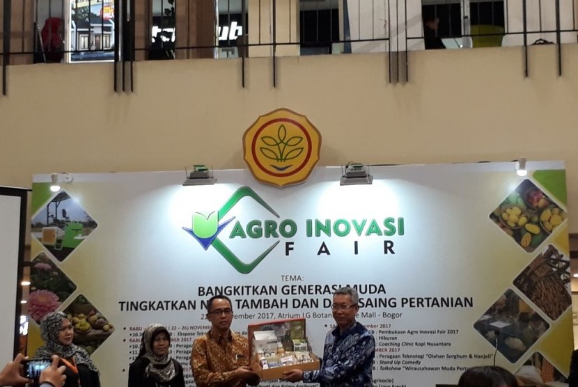 Kepala Balitbangtan Muhammad Syakir (kanan) menerima bingkisan dari Ketua Panitia AIF 2017 Muhammad Prama Yufdy usai membuka Agro Inovasi Fair 2017 di Botani Square, Bogor, pada Sabtu (25/11).