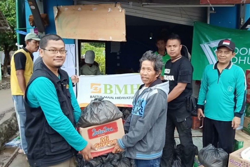 Kepala BMH Lampung menyerahkan bantuan kepada korban tsunami  warga Desa Kunjir dan Desa Way Muli, Kecamatan Rajabasa, Lampung Selatan.   