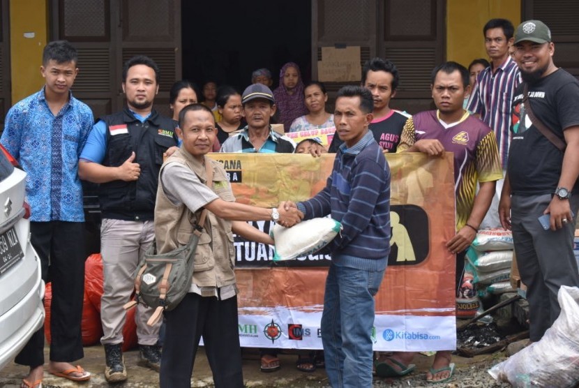 Kepala BMH Perwakilan Banten,  Bati menyerahkan bantuan kepada warga Desa Ciladeuen yang diwakili oleh jaro Desa Ciladeuen, Senin  (13/1).