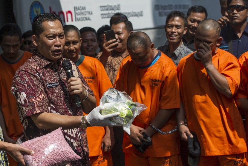 Kepala BNN Komjen Pol Budi Waseso (kiri) menunjukkan barang bukti dan pelaku dalam rilis pengungkapan jaringan sindikat narkotika internasional di Kantor BNN, Jakarta Timur, Jumat (13/5). 