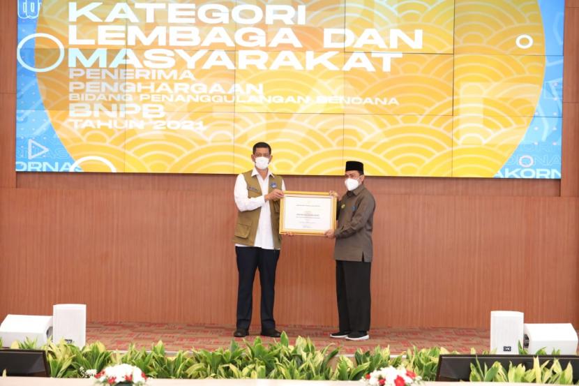 Kepala BNPB Doni Monardo menyerahkan penghargaan kepada Pimpinan Baznas RI Drs KH Achmad Sudrajat, Lc, MA dalam acara Rapat Koordinasi Nasional Penanggulangan Bencana (Rakornas PB) tahun 2021 di Graha BNPB Jakarta, Rabu (10/3).
