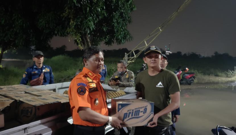  Kepala BPBD Kabupaten Tangerang, Ujat Sudrajat (kiri) menyerahkan bantuan bagi warga korban bencana.