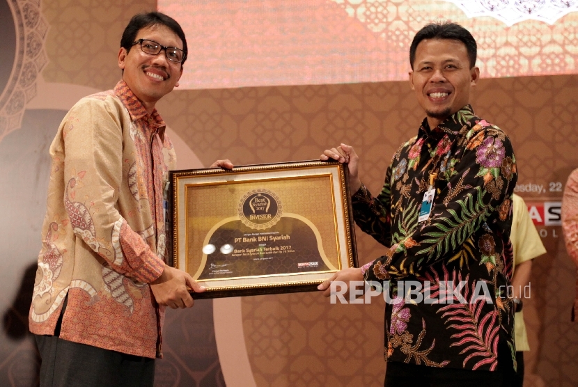 Kepala Departemen Ekonomi dan Keuangan Syariah (DEKS) Bank Indonesia, Anwar Basori memberikan piagam kepada General manager BNI Syariah M. Misbahul Munir pada acara Best Syariah 2017 di Jakarta, Selasa (22/8).