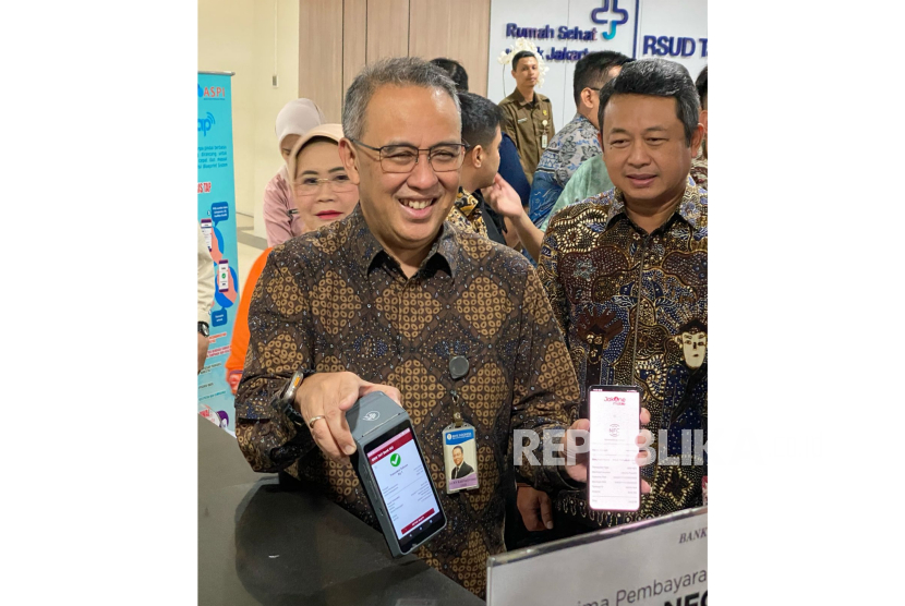 Kepala Departemen Kebijakan Sistem Pembayaran Bank Indonesia Dicky Kartikoyono menunjukkan hasil transaksi menggunakan QRIS Tap di RSUD Tarakan, Jakarta Pusat, Jumat (14/3/2025). 