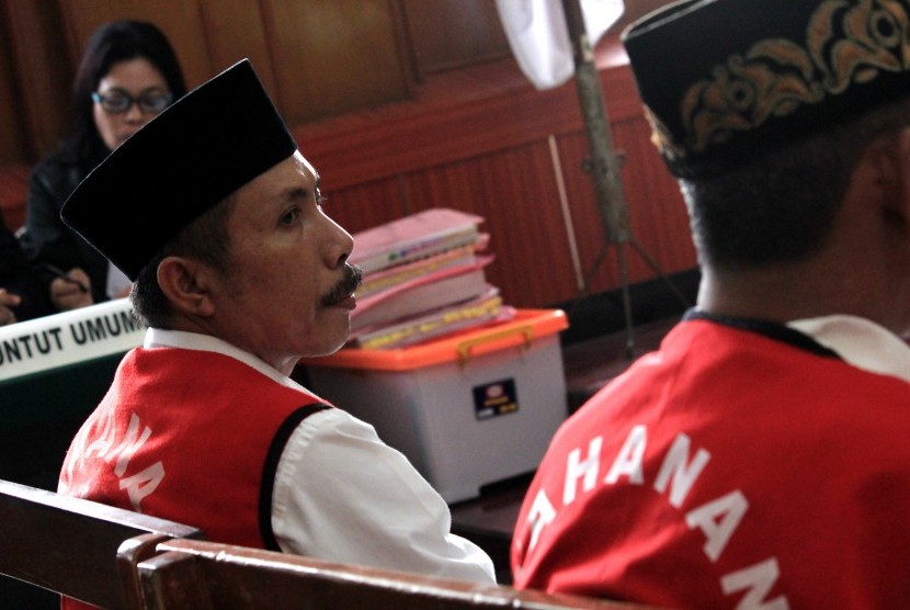 Kepala Desa Selo Awar-Awar Lumajang, Hariyono (kiri) mengikuti sidang perdana kasus dugaan pembunuhan aktivis lingkungan Salim Kancil di Pengadilan Negeri (PN) Surabaya, Jawa Timur, Kamis (18/2). 