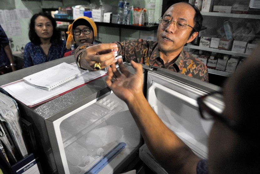 Kepala Dinas Kesehatan Provinsi Bali, Ketut Suarjaya (kanan) bersama Kepala Balai Besar Pengawasan Obat dan Makanan (BBPOM) Denpasar Endang Widowati (kedua kiri) memeriksa vaksin saat inspeksi peredaran vaksin palsu di rumah sakit Bali Med, Denpasar, Kamis