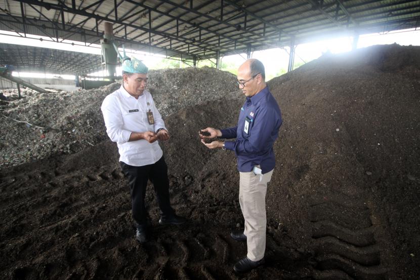 Kepala Dinas Lingkungan Hidup dan Kebersihan Kabupaten (DLHK) Sidoarjo Bahrul Amiq (kiri) dan Direktur Operasi 2 PT Pembangkitan Jawa-Bali (PJB) Rachmanoe Indarto (kanan) melihat bahan baku pengganti batu bara (co-firing) biomassa yang berasal dari sampah di Tempat Pembuangan Akhir (TPA) Sampah di Jabon, Sidoarjo, Jawa Timur, Rabu (13/7/2022). PT PJB bekerja sama dengan Pemerintah Kabupaten Sidoarjo mengirimkan Bahan Bakar Jumputan Padat (BBJP) pertama sebanyak 160 ton yang digunakan sebagai bahan bakar pengganti batu bara (co-firing) di PLTU Tanjung Awar-Awar dan PLTU Paiton.