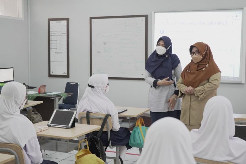 Kepala Dinas Pendidikan DKI Jakarta, Nahdiana (kanan) melakukan peninjauan pelaksanaan Pembelajaran Tatap Muka Terbatas (PTMT) dengan kapasitas 100 persen di Sekolah Bakti Mulya (BM) 400 Jakarta, Senin (10/1).