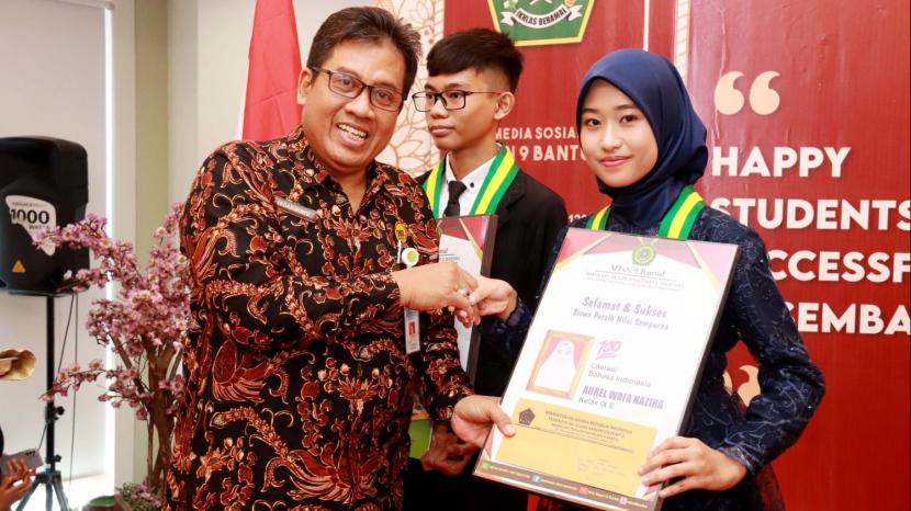 Kepala Dinas Pendidikan Pemuda dan Olahraga (Disdikpora) Kabupaten Bantul Isdarmoko menyerahkan apresiasi untuk kedua siswa saat Wisuda Purnasiswa Kelas IX Tahun Ajaran 2022/2023 di Gedung Erlangga, Sabtu (10/6/2023).