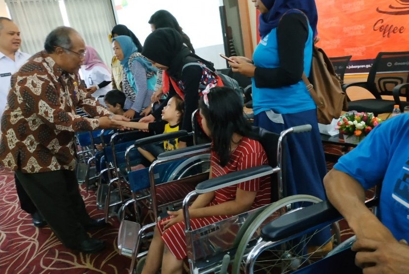 Kepala Dinas Sosial Jabar Dodo Suhendar, memberikan bantuan kursi roda di Kantor Dinsos Jabar, Rabu (16/10).
