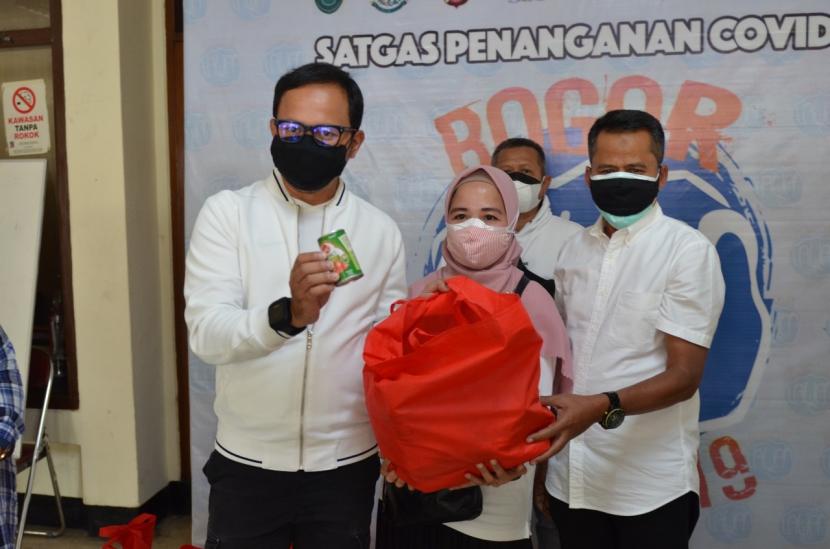 Kepala Dispusipda Jabar Dr. Ir. H. Ahmad Hadadi, M.Si (kanan) secara simbolis menyerahkan bantuan pada warga terdampak Covid-19 di Bogor. Diterima langsung oleh Walikota Bogor Bima Arya.