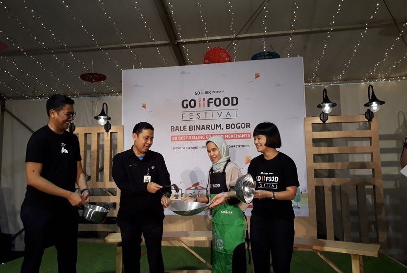 Kepala Ekspansi Komersial Gojek Catherine Hindra Sutjahyo (kanan) dan Kepala Dinas Koperasi dan UMKM Kota Bogor Anas S Rasmana (ke dua dari kiri) meluncurkan Go Food Festival di bekas Bale Binarum, Bogor pada Rabu (14/2).