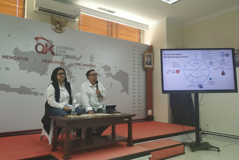 Kepala Group Inovasi Keuangan Digital (IKD) Otoritas Jasa Keuangan (OJK) Triyono (kanan) dalam konferensi pers di kantornya, Jakarta, Jumat (19/7).
