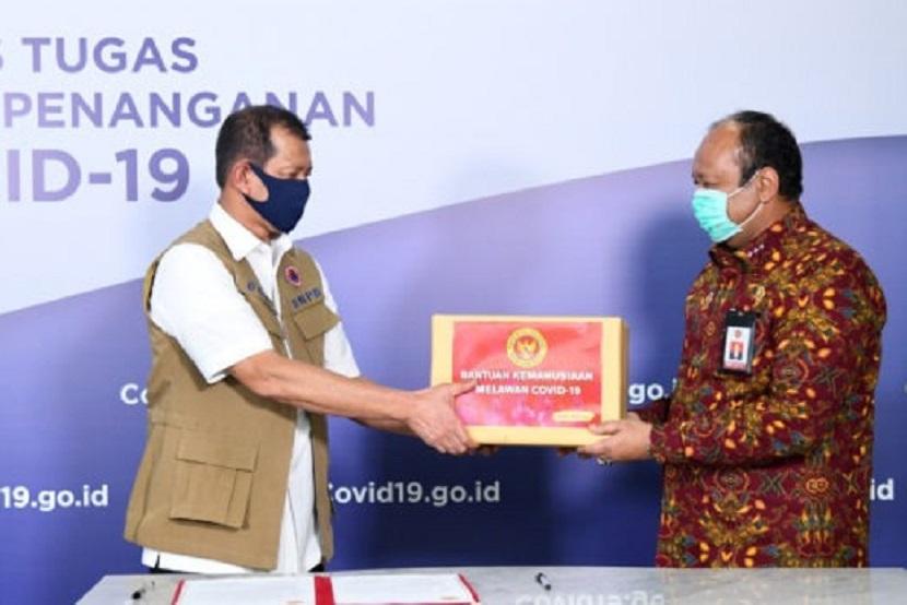 Kepala Gugus Tugas Percepatan Penanganan Covid-19 Doni Monardo (kiri) menerima bantuan alat kesehatan (alkes) dan APD dari Wakil Kepala Badan Intelijen Negara (BIN) Teddy Lhaksmana Widya Kusuma (kanan) di Graha BNPB, Jakarta, Jumat (17/4).   
