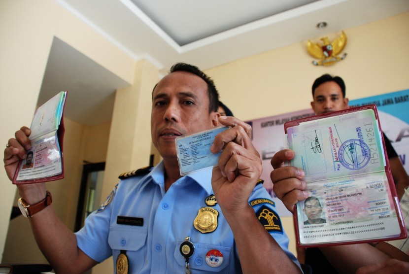 Kepala Kantor Imigrasi III Bekasi Is Edy Eko Putranto (kiri) didampingi jajarannya menunjukkan sejumlah barang bukti dokumen paspor dan KTP palsu calon haji yang gagal berangkat di Bekasi, Jawa Barat, Kamis (27/8).