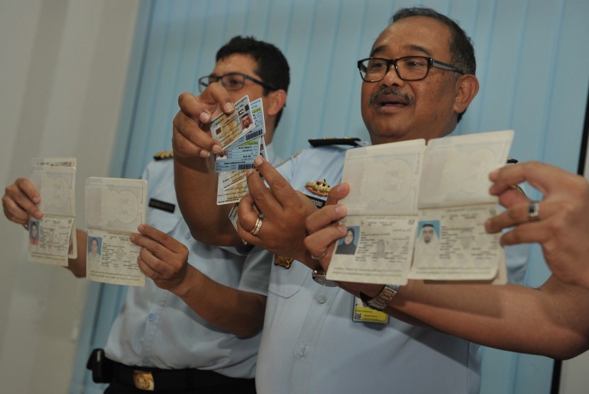 Kepala Kantor Imigrasi Ngurah Rai, Yosep H.A Renung Widodo (kanan) bersama staf menunjukkan kartu identitas dan paspor warga negara asing (WNA) yang melanggar keimigrasian di Kantor Imigrasi Ngurah Rai, Denpasar, Kamis (8/10).