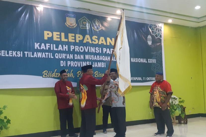 Kepala Kanwil Kemenag Agama Papua Klemens Taran (kanan) saat menyerahkan bendera pataka kepada Ketua kafilah STQ Papua Alwie Tien Lean.