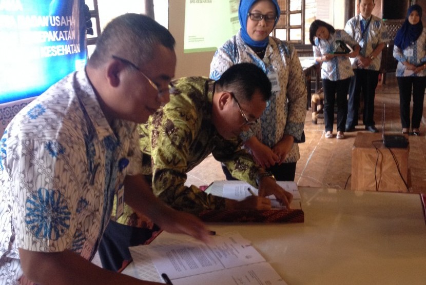 Kepala Kejaksaan Negeri Bandung Dwi Hartanta (tengah) dan Kepala BPJS Kesehatan cabang utama Bandung Gatot Subroto (kiri) menandatangani nota kesepakatan tentang Efektivitas Rekrutmen Kepesertaan BPJS Kesehatan di Bandung, Selasa (19/5). 