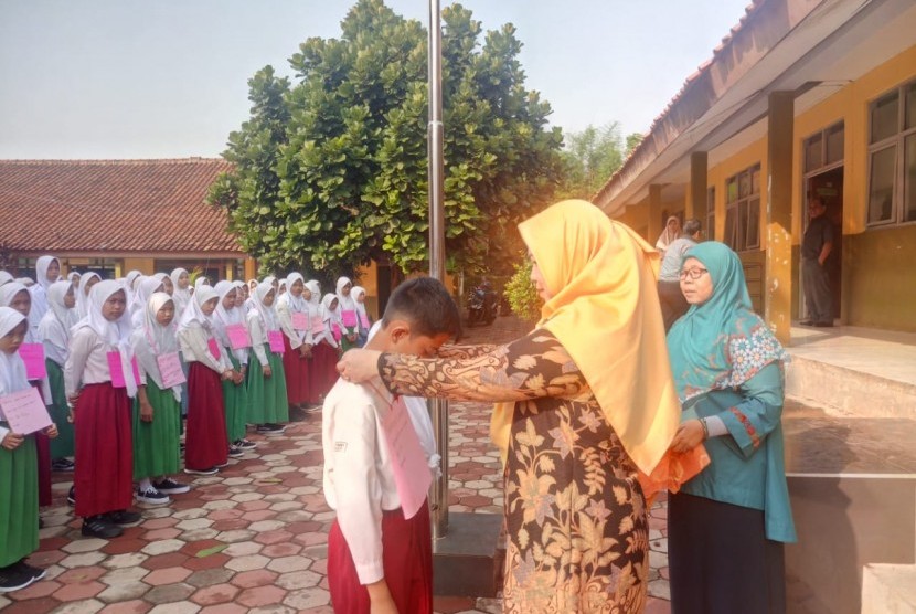 Kepala MTsN 1 Bogor, Etty Munyati menyematkan tanda peserta kepada siswa baru peserta Masa Ta