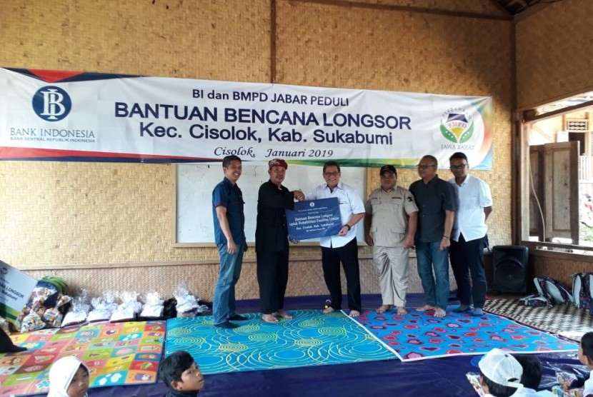 Kepala Perwakilan Bank Indonesia Provinsi Jawa Barat Doni P Joewono menyerahkan bantuan kepada korban longsor di Desa Sirna Res Kecamatan Cisolok, Kabupaten Sukabumi Selasa (8/1). Bantuan diterima oleh ketua atau pemangku adat Kasepuhan Adat Sinar Resmi Abah Asep Nugraha.