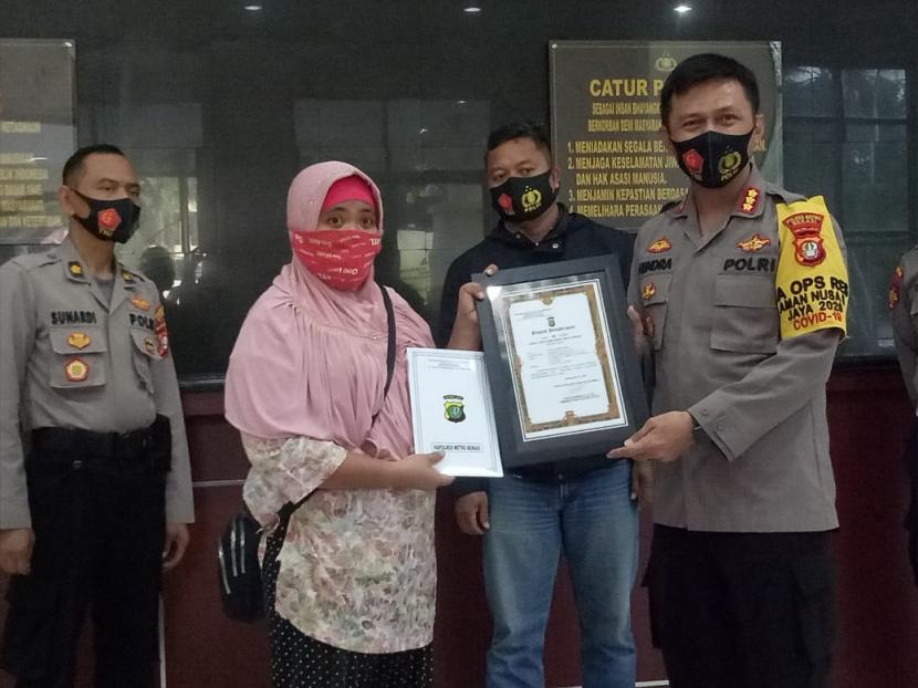 Kepala Polres Metro Bekasi, Kombes Hendra Gunawan beri penghargaan kepada ojol perempuan, Dwi Wulan Meilani. 