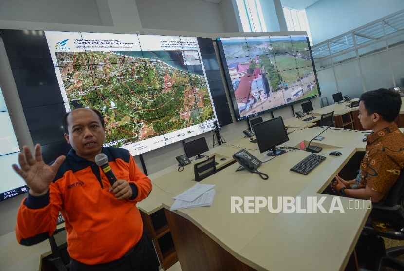 Kepala Pusat Data, Informasi, dan Humas Badan Penanggulangan Bencana (BNPB) Sutopo Purwo Nugroho lokasi bencana gempa di Provinci Aceh melalui layar di ruang pemantauan bencana Gedung BNPB, Jakarta, Jumat (9/12). BNPB mengklarifikasi jumlah korban meningga