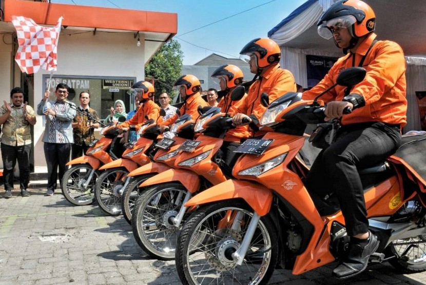   Kepala Regional 7 Jawa Timur Arifin Muchlis (memegang bendera) meresmikan aplikasi COD Pos yang ditandai dengan memberangkatkan para pengantar Pos di Kantor Pos Jombang, Jumat (26/7).