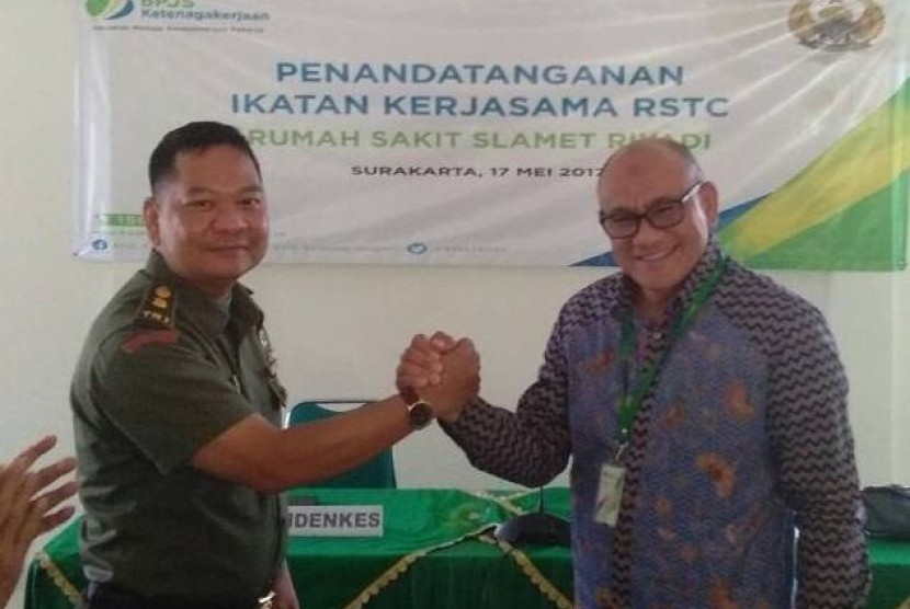 Kepala Rumah Sakit Slamet Riyadi Mayor ckm dr Ridwan Dwi Sapitro (kiri) berjabat tangan dengan Kepala Kantor BPJS Ketenagakerjaan Cabang Surakarta Suwilwan Rachmat usai penandatanganan Ikatan Kerja Sama (IKS) antara kedua lembaga di Solo, Jawa Tengah, Jumat (19/5). IKS tersebut menjadikan Rumah Sakit Slamet Riyadi sebagai Rumah Sakit Trauma Center (RSTC).