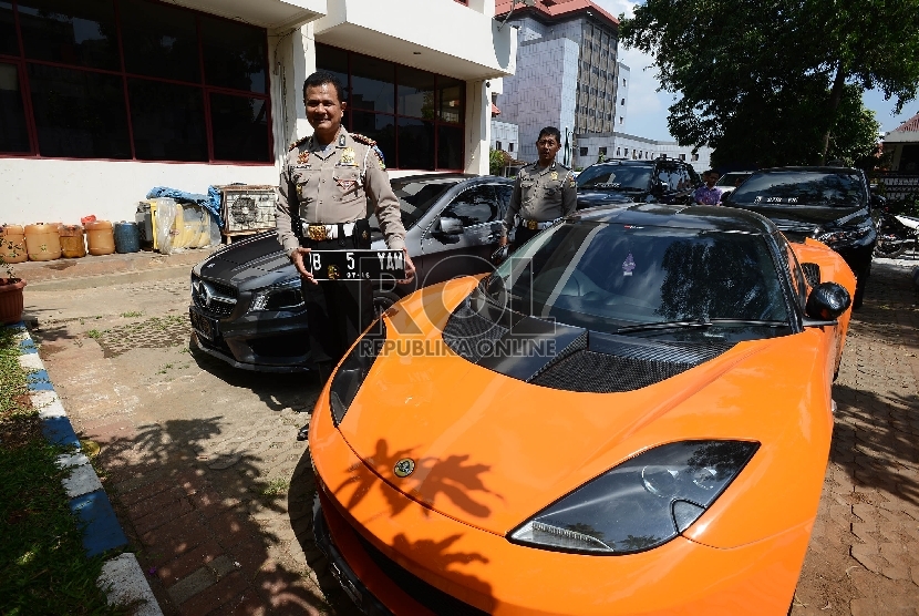 Kepala Satuan Lalu Lintas (Kasat Lantas) Polres Jakarta Utara, AKBP Sudharmanto menunjukan plat nomor palsu dari mobil mewah yang telah diamankan di kantor Samsat Jakarta Utara, Kamis (28/5). (Republika/Raisan Al Farisi)