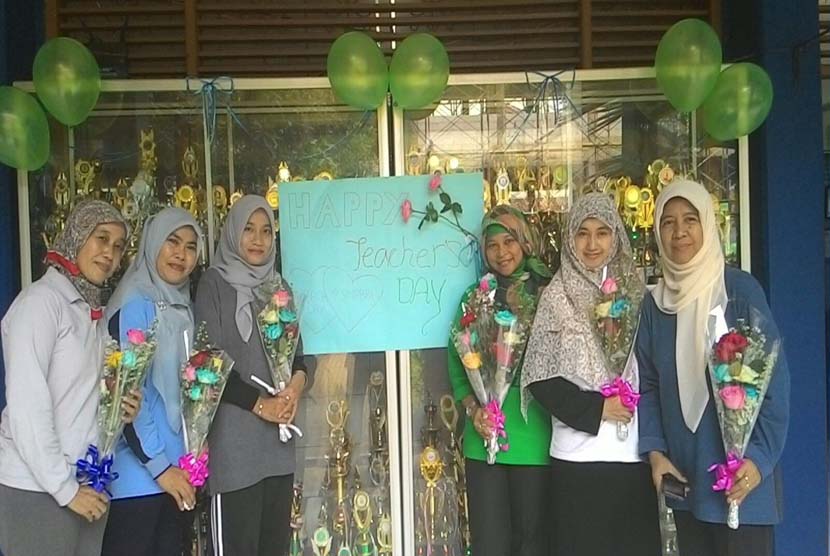 Kepala sekolah dan guru SMP Bosowa Bina Insani sumringah menerima hadiah bunga dari para siswa pada  Hari Guru, Rabu (25/11).
