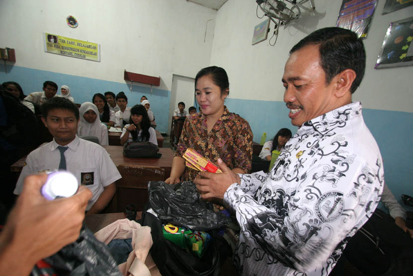  Kepala Sekolah SMA Negeri 5, Sutrisno menyita coklat dari tas milik siswa saat merazia kado Valentine di Medan, Sumut, Kamis (14/2).  (Antara/Septianda Perdana)