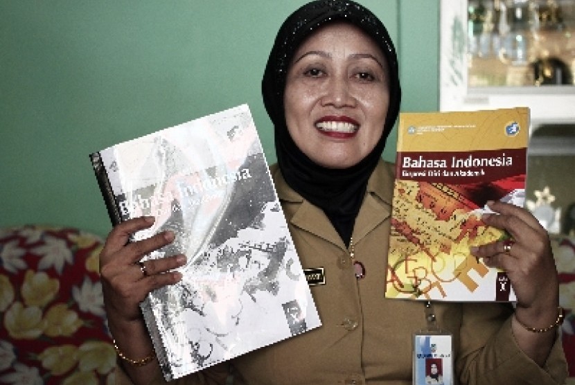 Kepala Sekolah SMU Negeri 4 Batam, Tapi Winanti menunjukkan buku pelajaran Bahasa Indonesia kurikulum 2013 dan fotokopiannya di Batam, Senin (26/8). 
