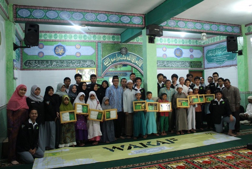 Kepala SMA Labschool Jakarta Suparno Sastro dan pengurus Rohis bersama dengan anak-anak yatim dan pengurus panti asuhan Yayasan Darussalam Biaunillah.