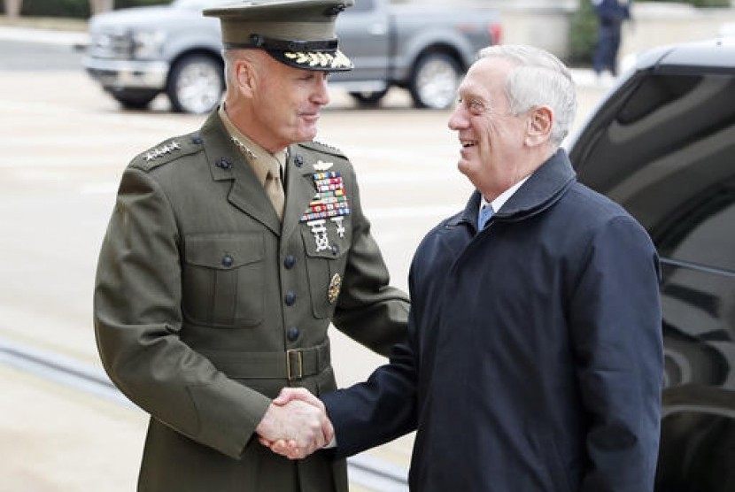 Kepala Staf Gabungan Jenderal Joseph Dunford (kiri) berjabat tangan dengan Menteri Pertahanan baru AS James Mattis saat tiba di Pentagon, Washington, Sabtu, 21 Januari 2017.