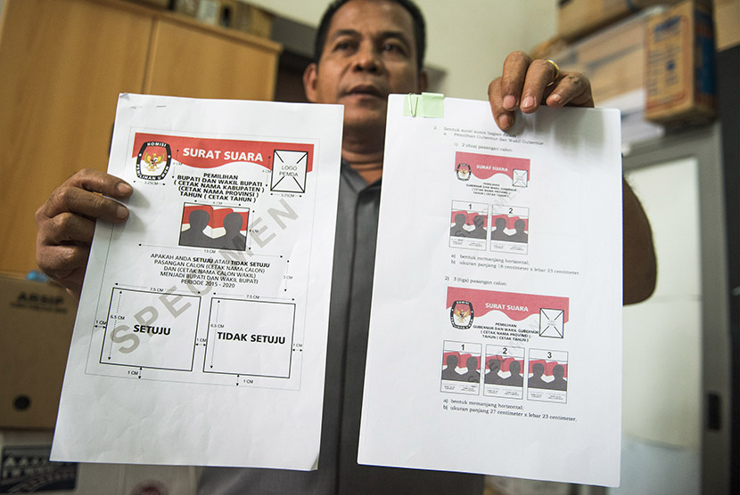 Kepala Subag Penyusunan Norma Desain dan Standar Kebutuhan Pemilu Biro Perencanaan Data KPU Sahono menunjukkan dua contoh surat suara untuk Pilkada serentak di KPU, Jakarta, Rabu (11/11).
