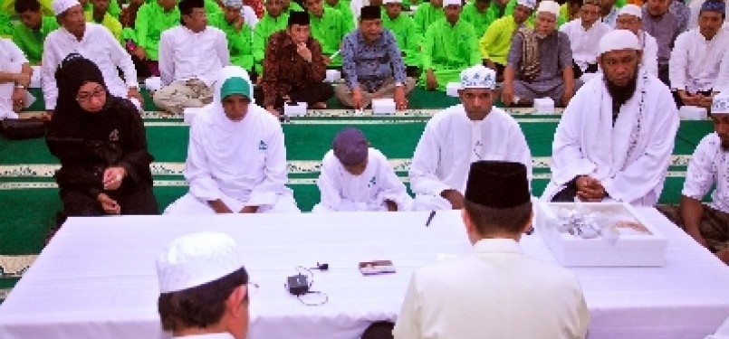 Kepala Suku Asmat Papua, Umar Abdul Kayimter (dua kanan), membaca dua kalimat Syahadat dengan didampingi istri dan putranya di Masjid Darussalam, Jatibening, Bekasi, Jawa Barat, Ahad (19/2). 