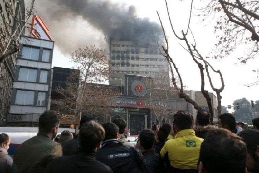 Kepulan asap kebakaran tampak dari gedung pusat perbelanjaan Plasco di kota Teheran, Iran. Gedung yang merupakan ikon kota Teheran ini dilalap api besar pada Kamis (19/1).
