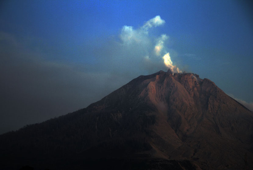 Kepulan asap putih membubung dari puncak Gunung Sinabung terlihat dari Desa Tiga Pancur, Karo, Sumatera Utara, Sabtu (9/1).