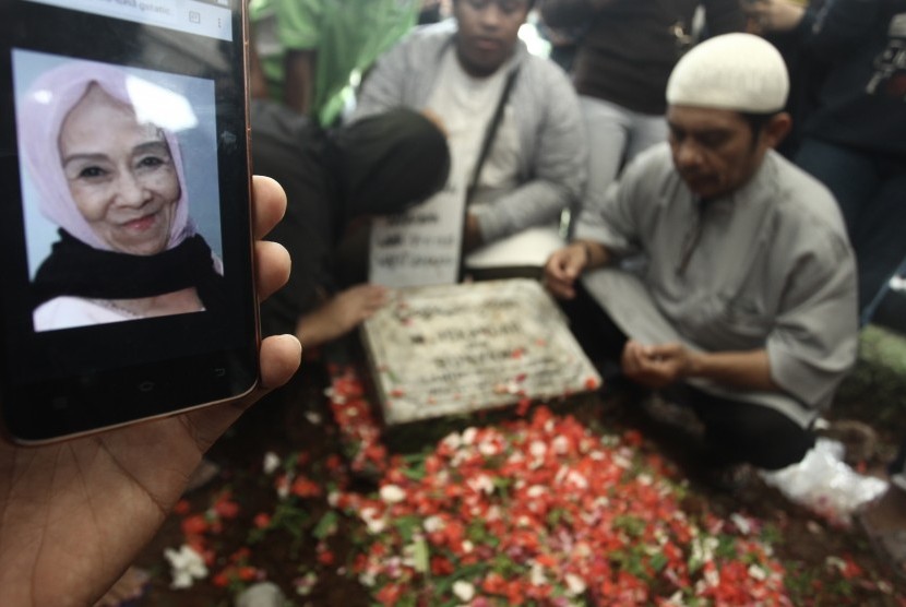 Kerabat berdoa di pusaran makam Penyanyi Laila Sari di TPU Karet Bivak, Jakarta, Selasa (21/11).