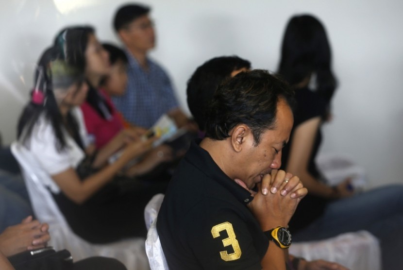 Kerabat korban AirAsia QZ8501 berdoa di gereja.