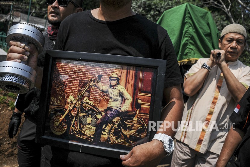 Kerabat membawa foto dan barbel selebriti almarhum Agung Santoso atau Agung Hercules saat akan dimakamkan di TPU Cikutra, Bandung, Jawa Barat, Jumat (2/8/2019). 