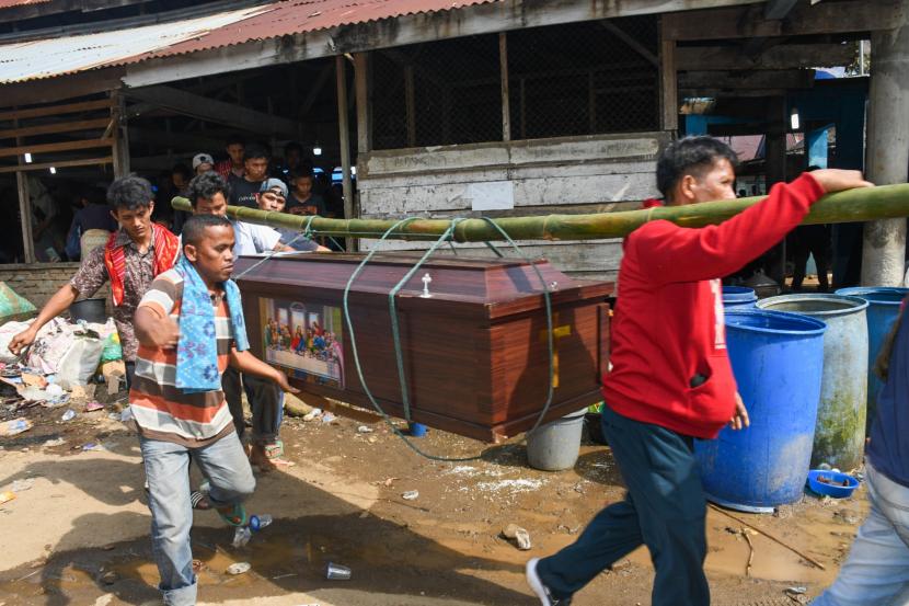 Kerabat membawa peti berisi jenazah korban penembakan kelompok kriminal bersenjata (KKB) Juda Gurusinga saat pemakaman di Desa Sayum Sabah, Sibolangit, Deli Serdang, Sumatera Utara, Senin (18/7/2022). Juda Gurusinga merupakan salah satu korban penembakan KKB di Papua. 