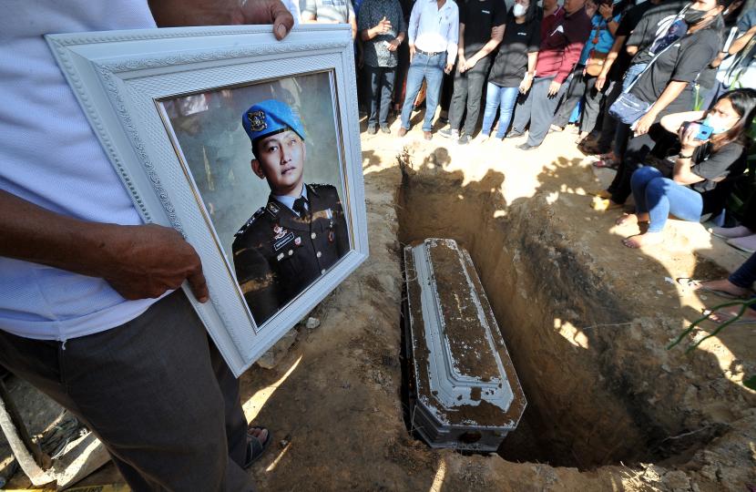 Kerabat memegang foto almarhum Brigadir Nofriansyah Yosua Hutabarat atau Brigadir J saat pemakaman kembali jenazah setelah autopsi ulang di Sungai Bahar, Muarojambi, Jambi, Rabu (27/7/2022). Autopsi ulang yang berlangsung selama enam jam itu dilakukan atas permintaan keluarga dalam mencari keadilan dan pengungkapan kasus. 