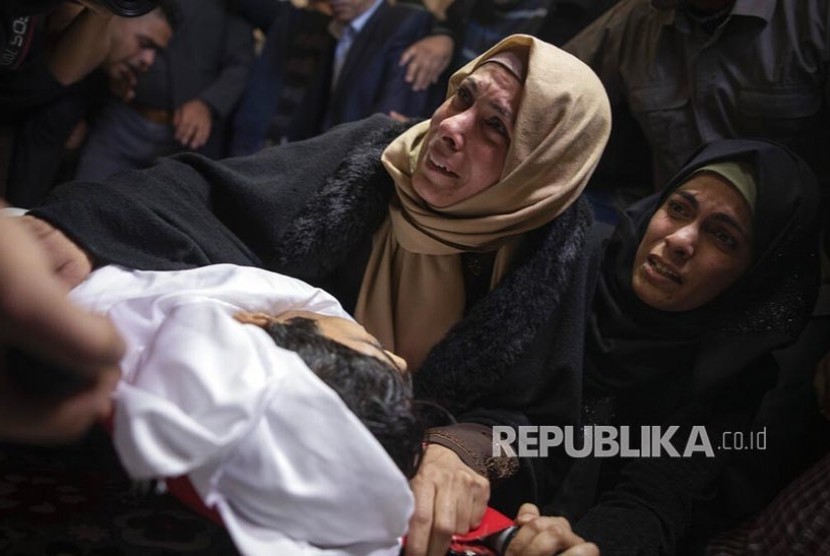 Kerabat menangisi jenazah  Fahed al-Astal (16) di Kota  Khan Younis, Jalur Gaza selatan. Pemuda Palestina ini ditembak di bagian perut oleh militer Israel. Kelompok HAM sebut lebih dari tiga ribu warga Palestina dibunuh dalam satu dekade. Ilustrasi.